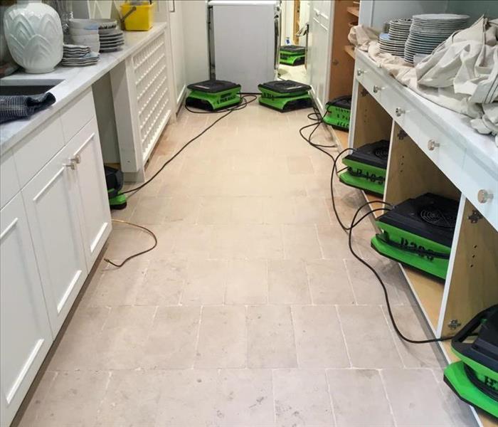 Air movers set up in the kitchen of a Delray Beach home after they experienced water damage